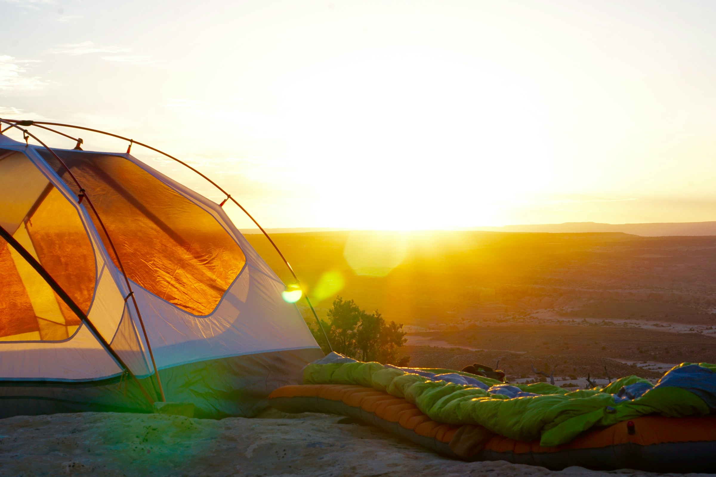 A tent and sleeping bag at sunrise